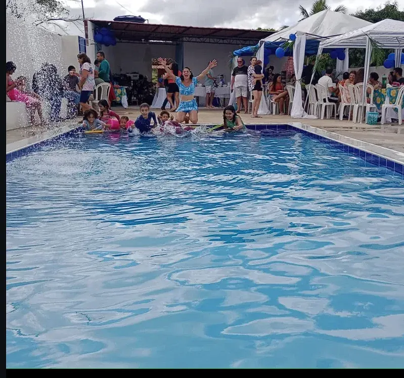 Comemoração no Espaço Acqua Pinheiro, com pessoas reunidas e crianças aproveitando a piscina